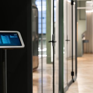 Тёмная кабина Framery One Compact рядом с рабочими местами